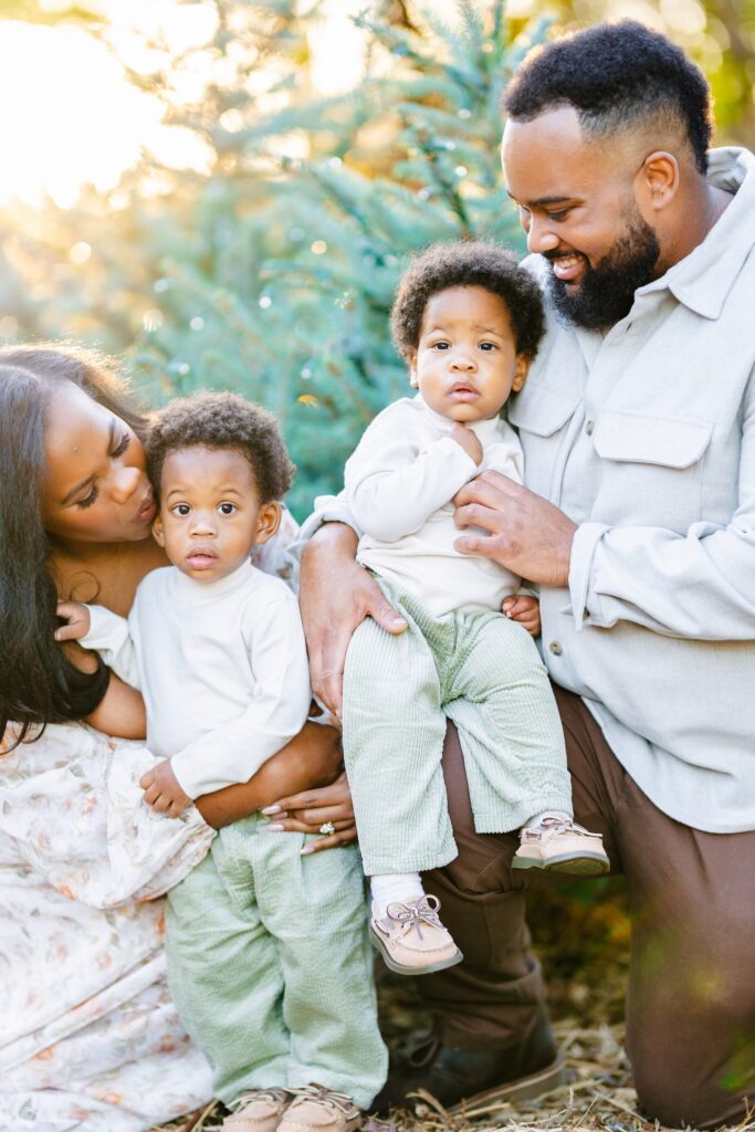 Parents cuddling their twin toddlers during a Dallas Arboretum family photography session.